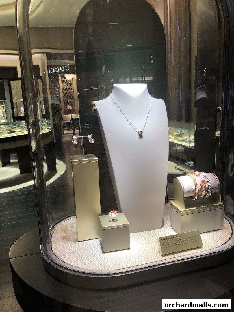 A display window showcasing Van Cleef & Arpels jewelry, including necklaces, rings, and bracelets.