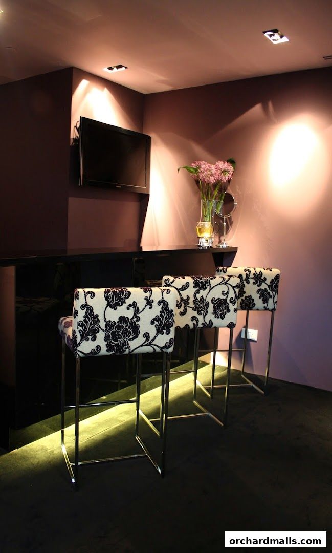 Interior shot of a medi-spa waiting area with decorative chairs and a TV.
