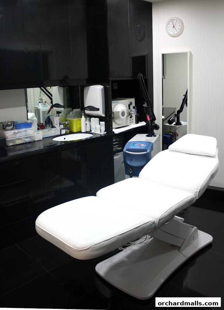 A clean and modern medi-spa treatment room with a reclining chair and medical equipment.