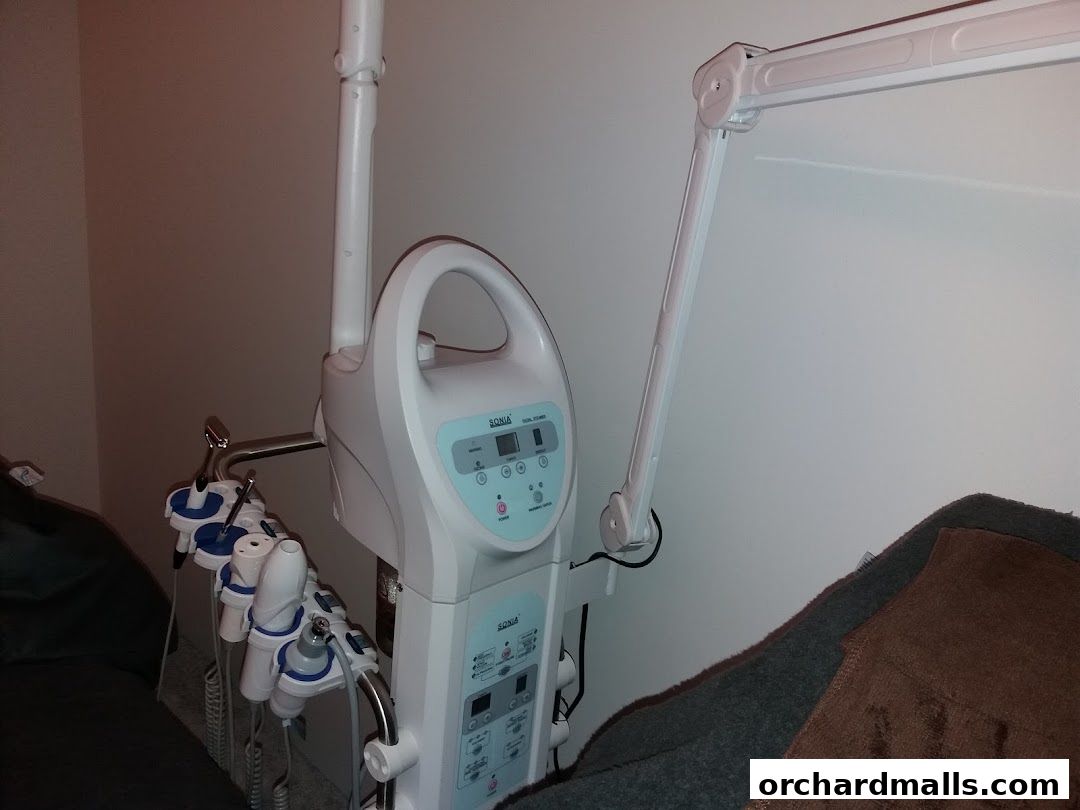 A medical spa machine with various attachments and a lamp in a treatment room.