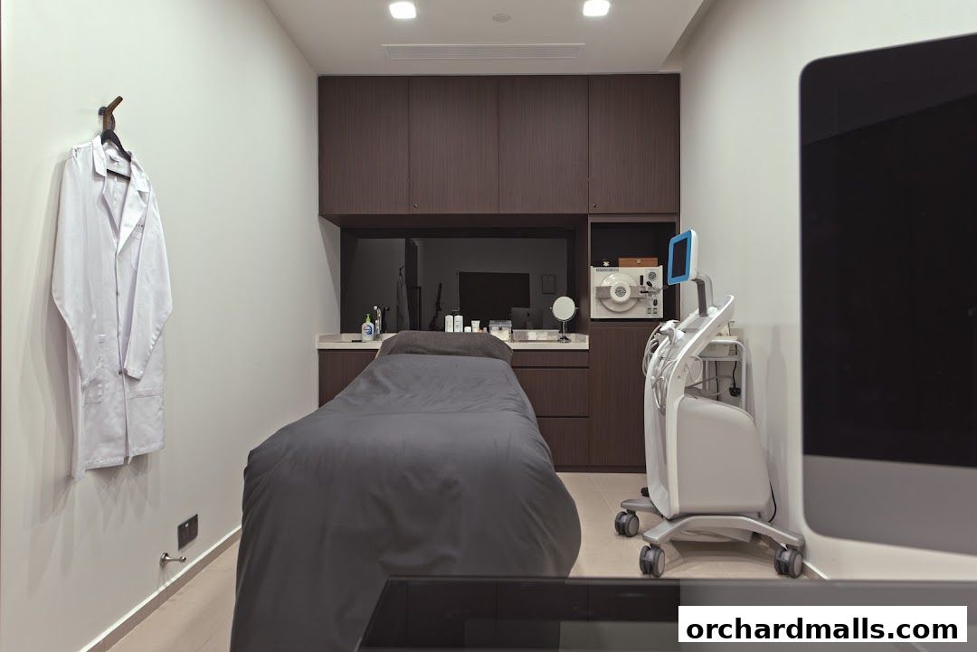 A clean and modern treatment room with a massage bed and medical equipment.