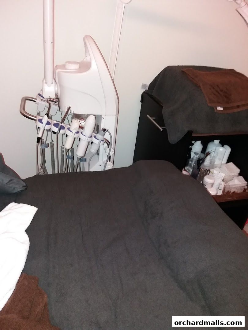 A treatment bed with medical spa equipment and products in a clean room.