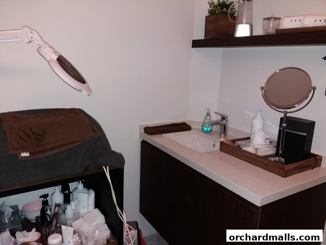 Interior of a medi-spa room with a sink, mirror, and treatment bed.