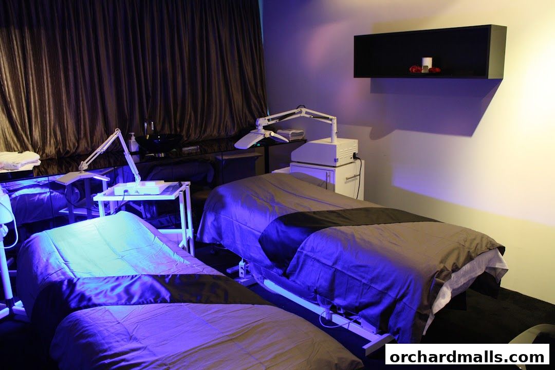 Two treatment beds with adjustable lamps in a dimly lit spa room.
