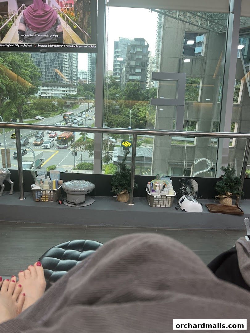 A person's feet with red nail polish are visible, covered by a blanket, in a spa setting.