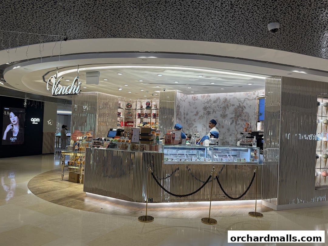 A Venchi chocolate and gelato shop with staff serving customers behind a display counter.