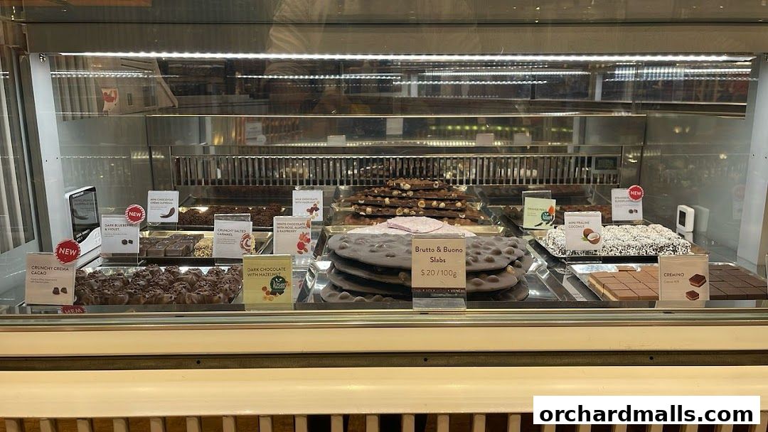 A display case filled with various artisanal chocolates, including slabs and small pieces.