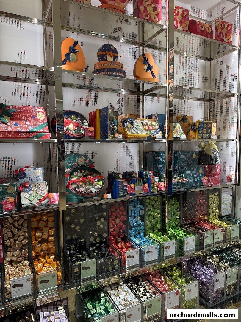 A wide selection of colorful, individually wrapped chocolates displayed in bins and boxes on shelves.