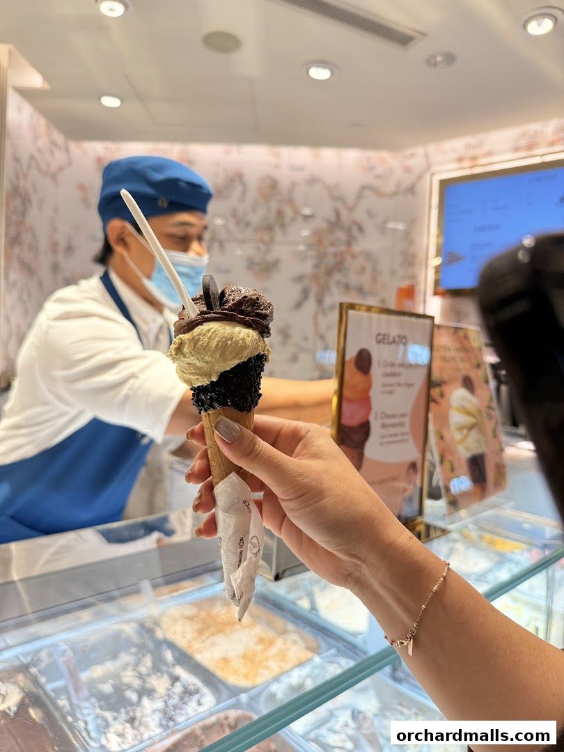 A customer receives a gelato cone from a server at Venchi Singapore ION Orchard.