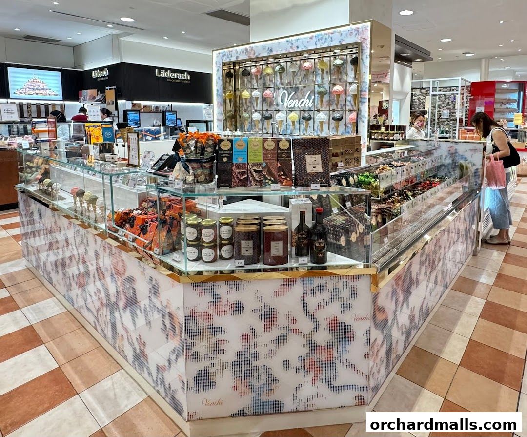 A Venchi chocolate shop display featuring ice cream cones, chocolates, and jars of spread.