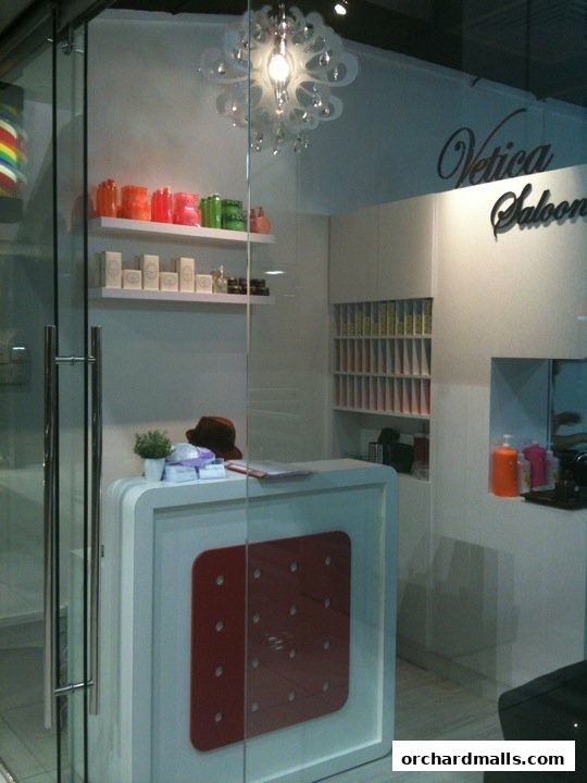 The entrance of Vetica Saloon, featuring a reception desk and shelves with products.