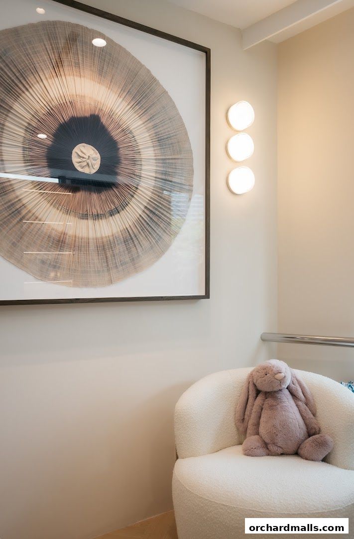 A plush bunny sits on a white armchair next to a large abstract artwork.