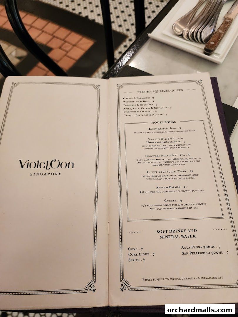 A menu from Violet Oon Singapore featuring freshly squeezed juices, house sodas, and soft drinks.