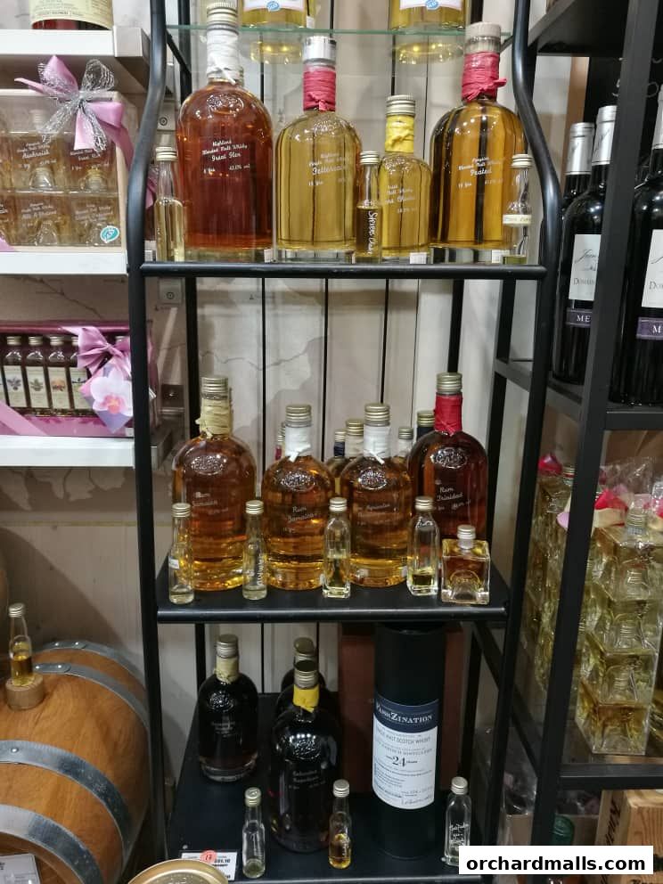 Shelves stocked with various bottles of spirits, including whisky and rum, and a wooden barrel.