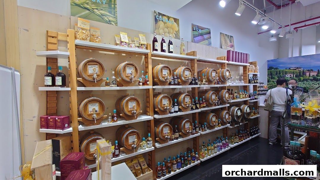 Interior view of a shop selling various bottles of spirits and liqueurs displayed on shelves with barrels.