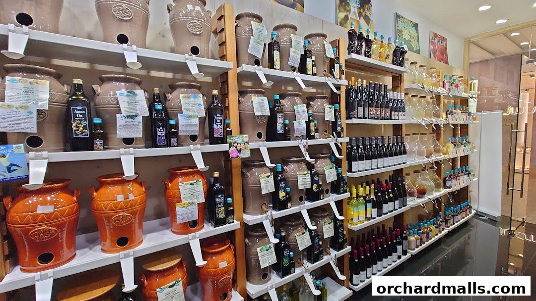Shelves stocked with various oils, vinegars, and spirits in bottles and large ceramic jars.