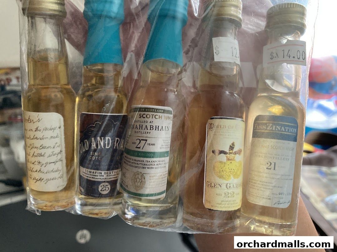 A collection of miniature whiskey bottles from Vom Fass ION, some with price tags.