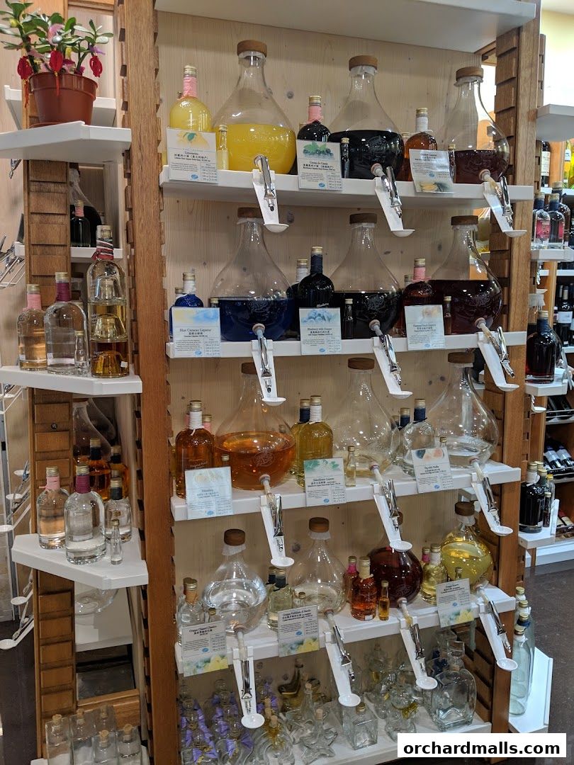 A display of various bottled spirits and liqueurs in large glass dispensers and smaller bottles.