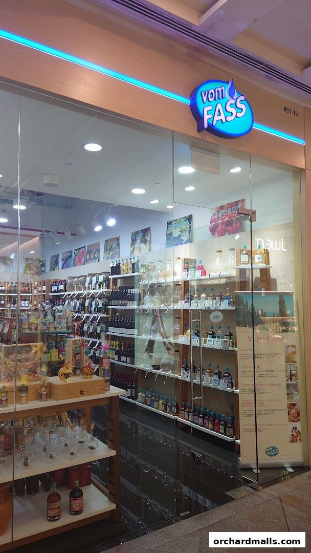 The exterior of a Vom Fass shop, showcasing a wide selection of bottled beverages and glassware.