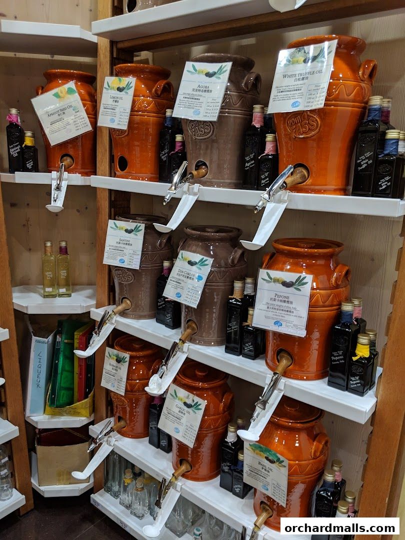 Shelves display large ceramic dispensers and bottles of various oils and liqueurs.