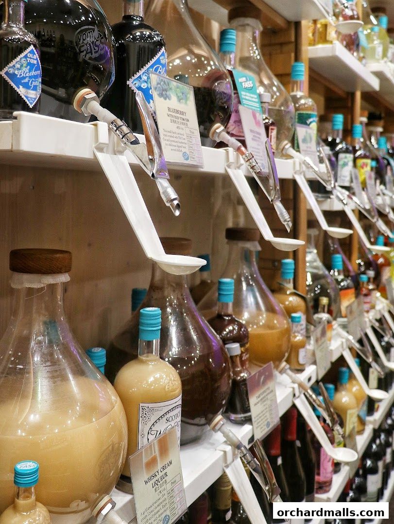 A display of various bottled liqueurs and spirits with dispensing taps on shelves.