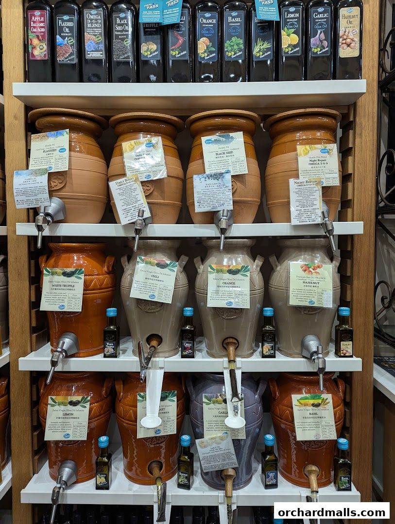 A display of various oils and vinegars in bottles and large ceramic dispensers.
