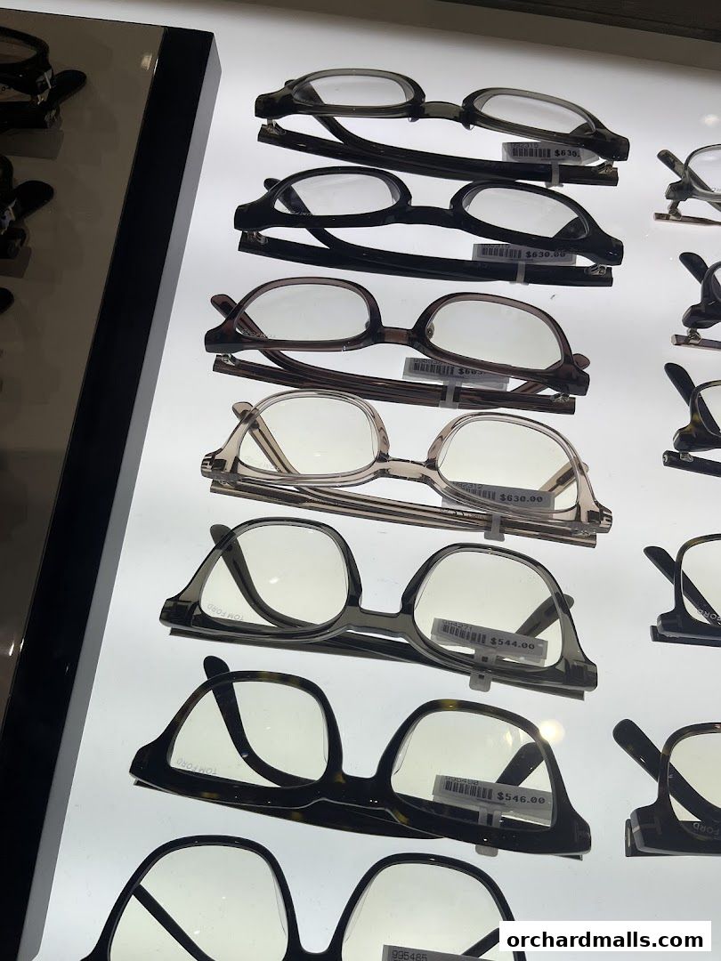 A display of various eyeglasses with price tags in a retail store.