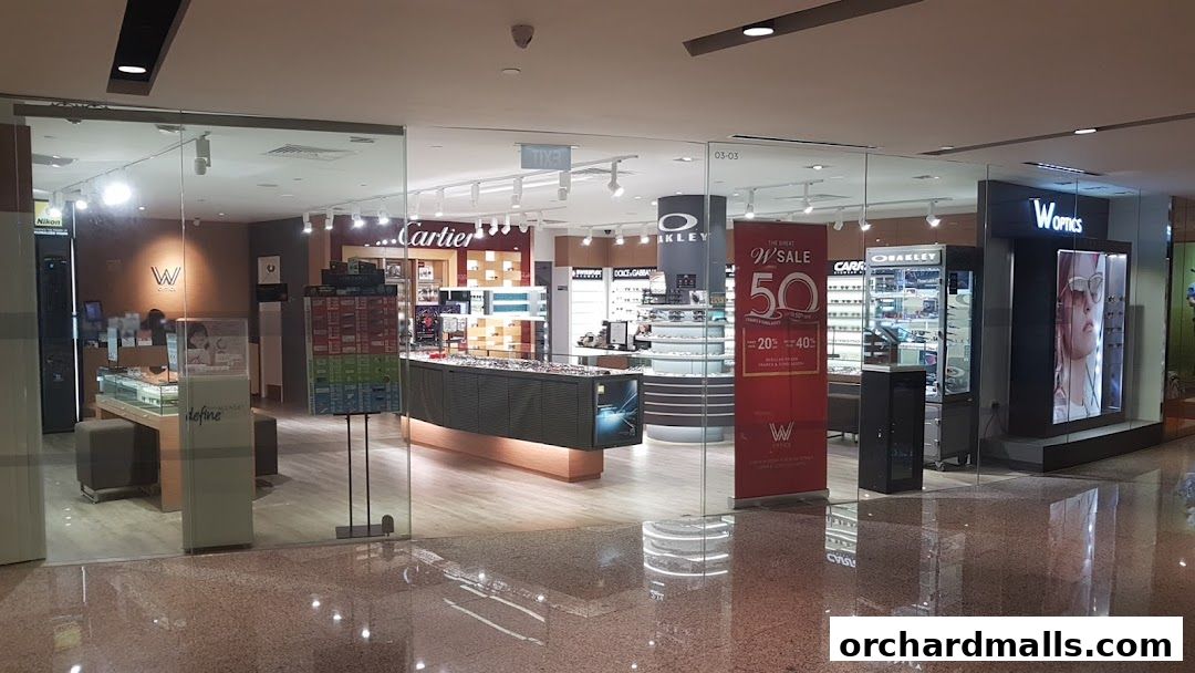The exterior of W Optics, an eyewear store, showcasing various brands and a sale banner.