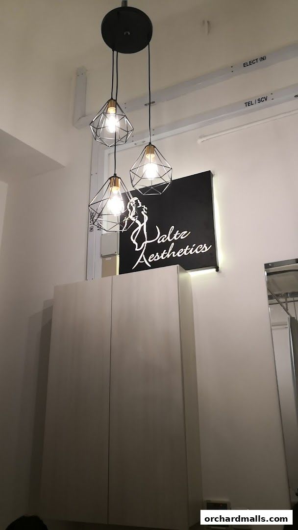 Interior shot of Waltz Aesthetics with a modern chandelier and logo.