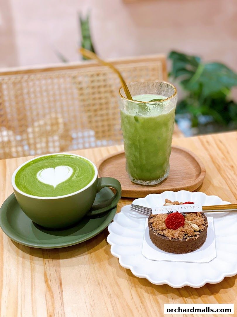 A matcha latte and a tart are beautifully presented on a wooden table.