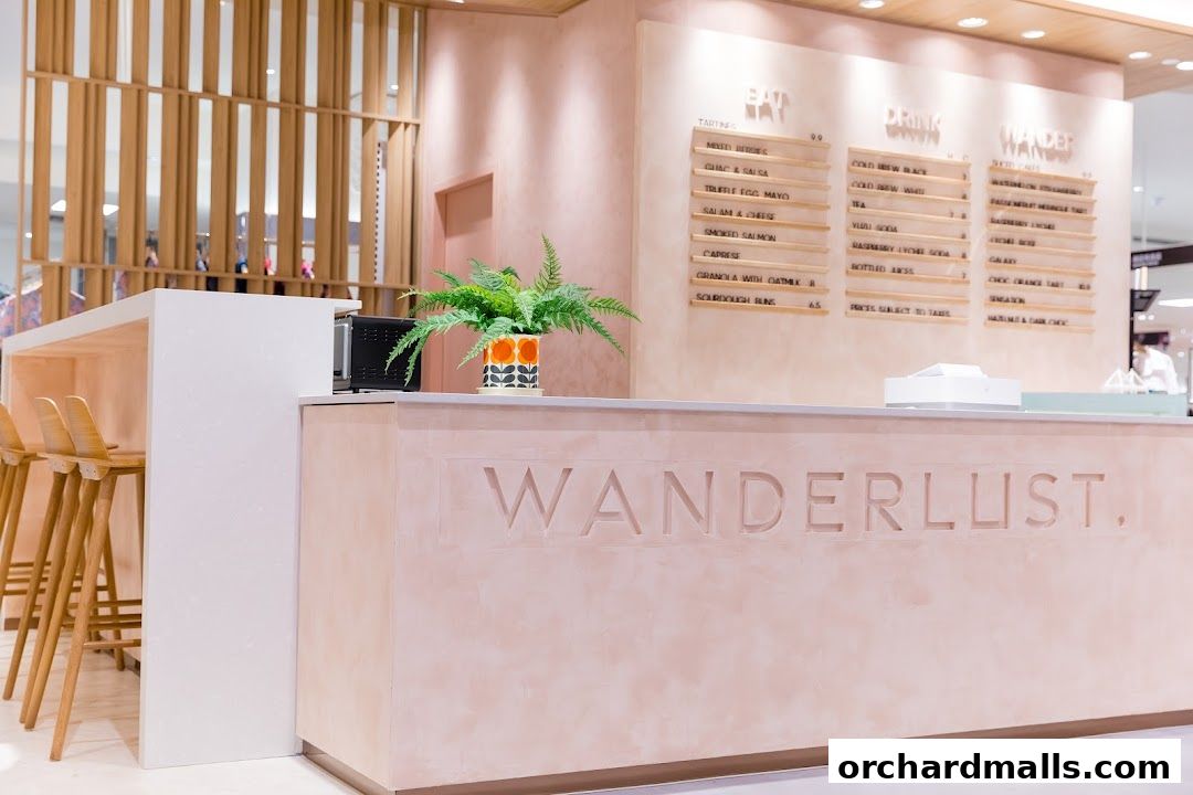 Interior view of Wanderlust Cafe with a pink counter, menu boards, and bar stools.