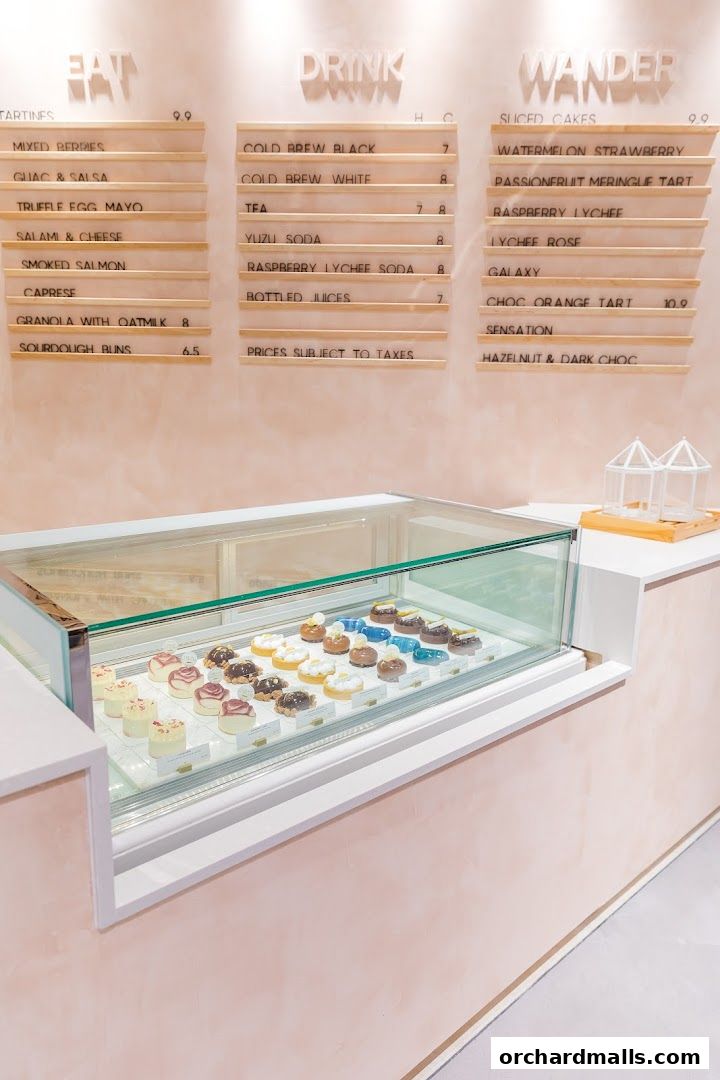 A menu board displays food and drink options above a display case of pastries.