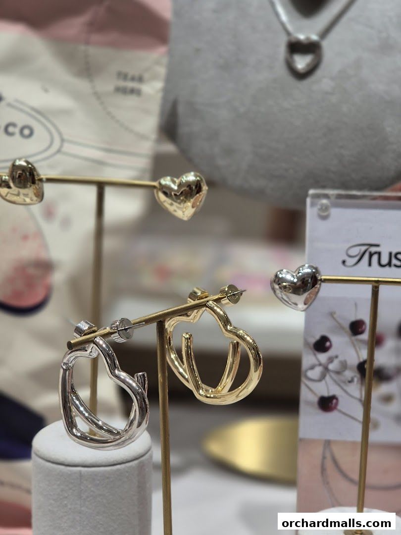 Close-up of heart-shaped earrings and necklaces displayed on stands.