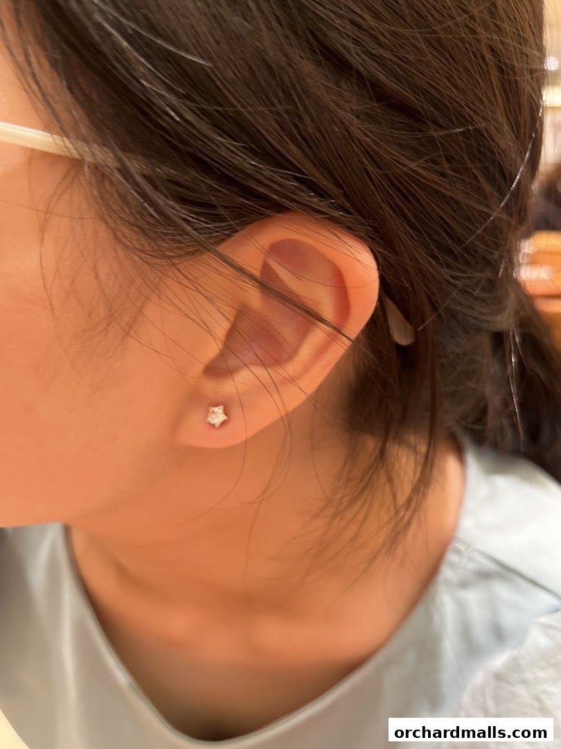 Close-up of a person's ear with a small star-shaped earring.