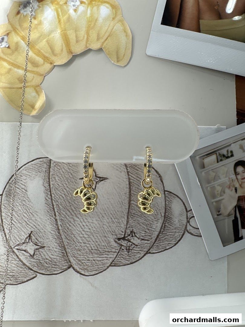 Close-up of cute dog-shaped earrings displayed with artistic sketches and photos.