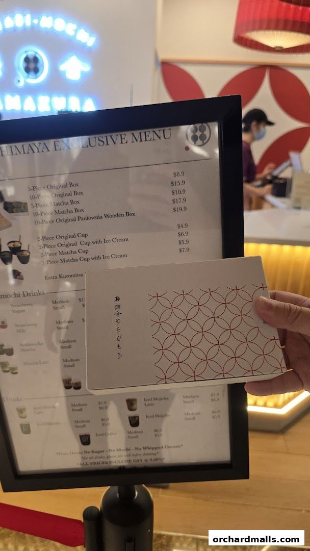 A menu board for Warabimochi Kamakura, showcasing various mochi boxes and drinks.