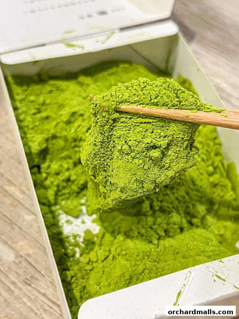 A close-up shot of warabimochi dusted with vibrant green matcha powder.