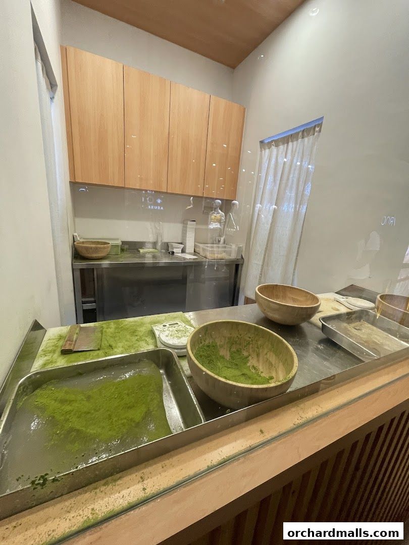 A clean kitchen counter with ingredients for making warabimochi, including matcha powder.