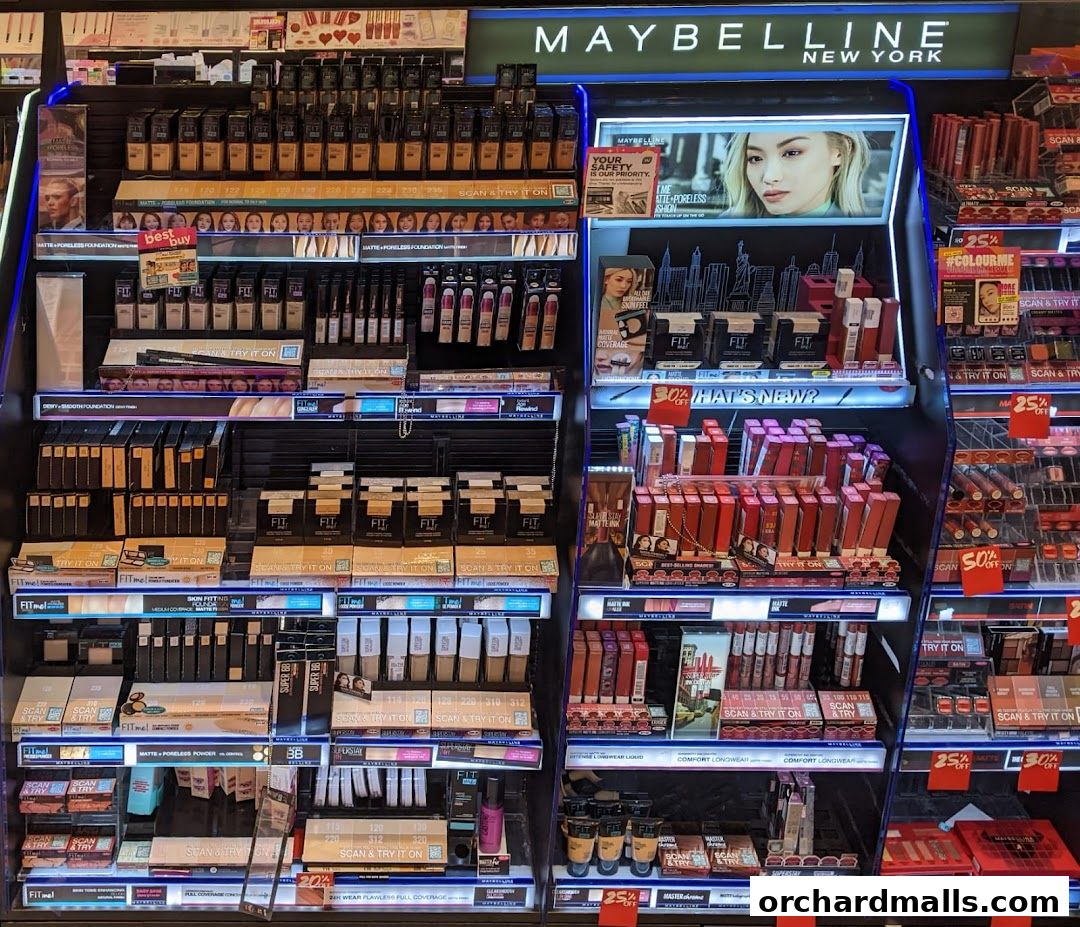 A display of Maybelline makeup products, including foundations, lipsticks, and BB creams.