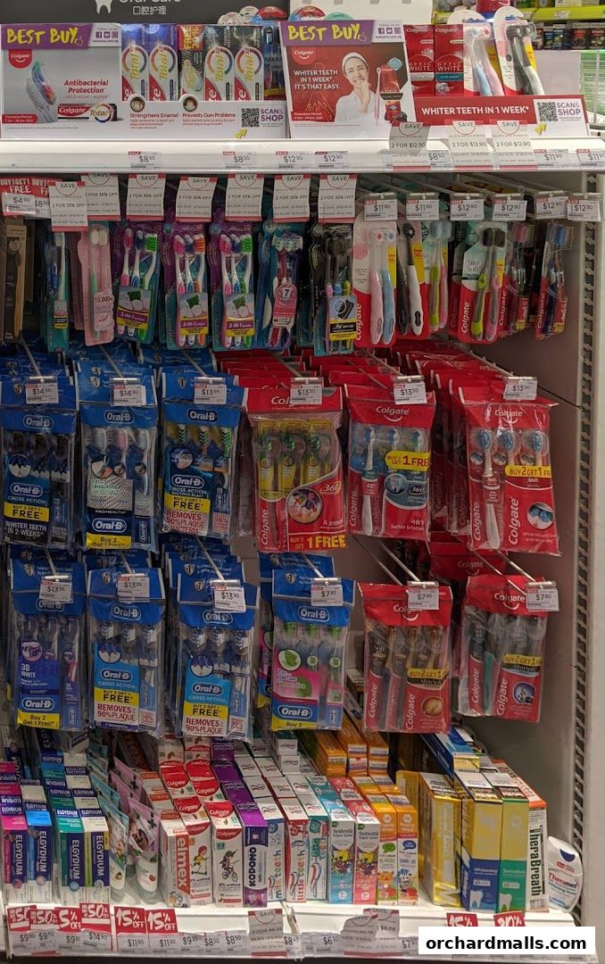 A display of various Colgate and Oral-B toothbrushes and toothpaste, with promotional signage.