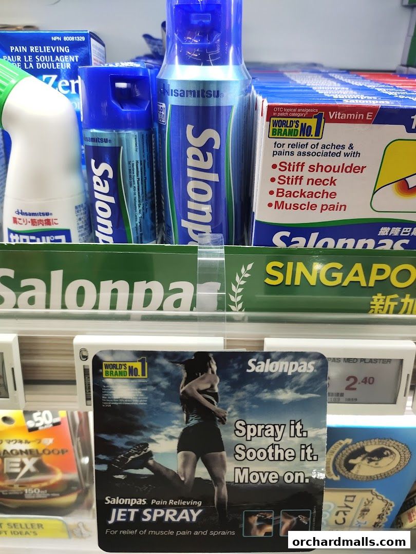 A display of Salonpas pain relief products, including sprays and patches, in a retail setting.