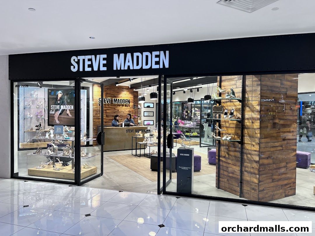 The exterior of a Steve Madden shoe store with shoes displayed in the window and inside.