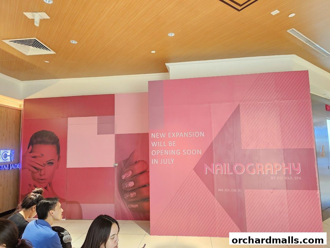 A pink construction hoarding announces the upcoming opening of Nailography by N20 Nail Spa.