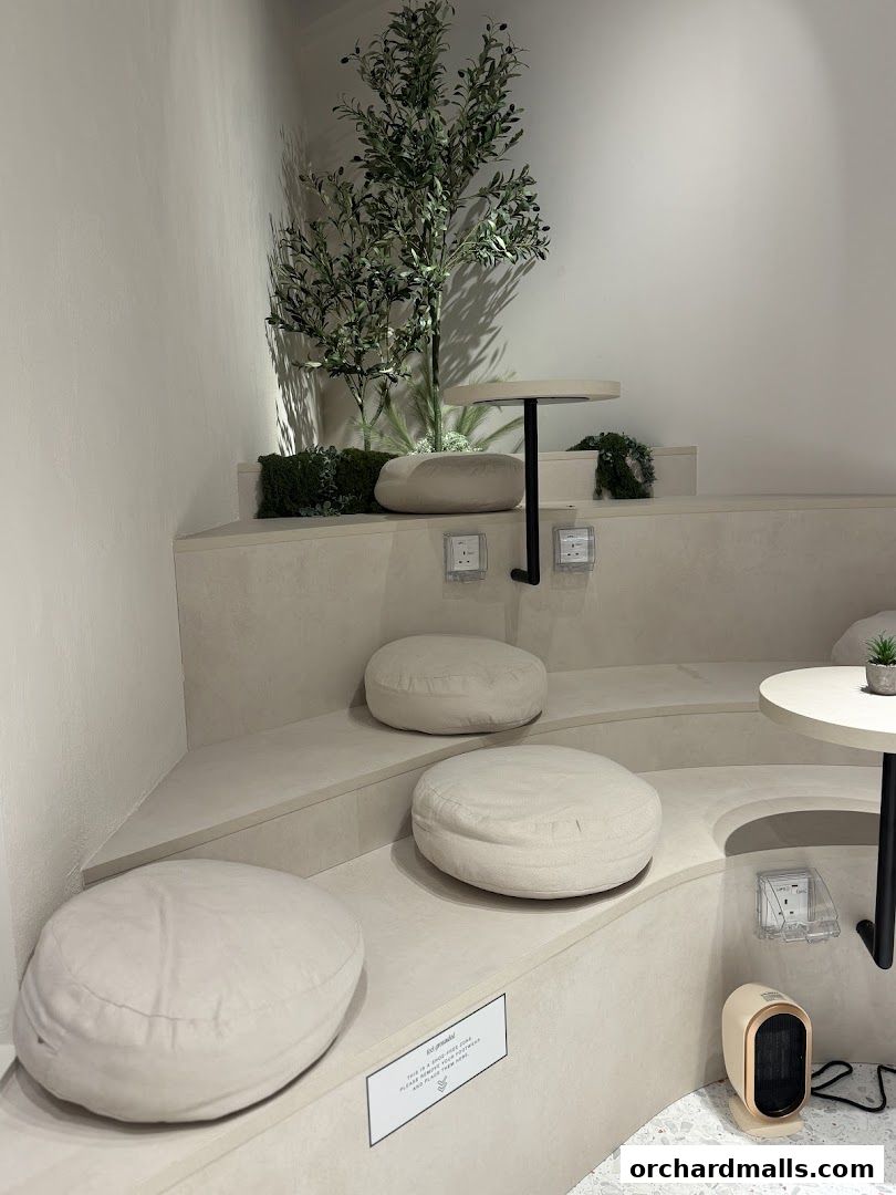 A serene seating area with floor cushions, small tables, and a decorative tree.