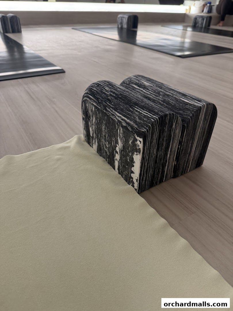 Yoga mats and blocks are neatly arranged on the floor of a studio.