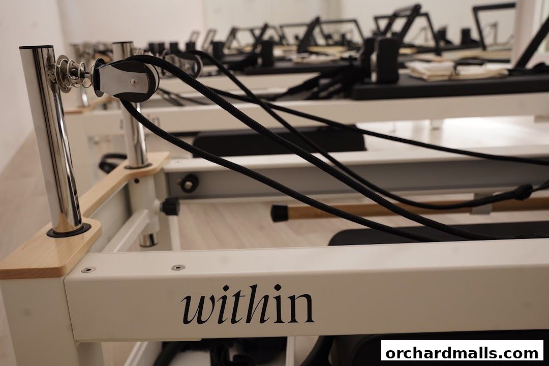 Interior shot of a yoga and pilates studio with reformers and equipment.