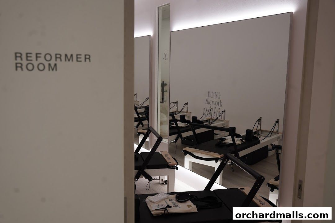 Reformer room with multiple pilates reformers and mirrors, ready for a workout.