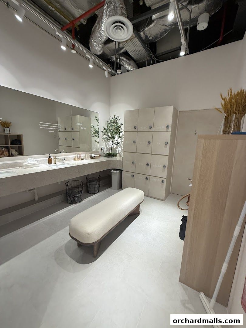 Interior of a clean and modern yoga and pilates studio changing room with lockers and a bench.
