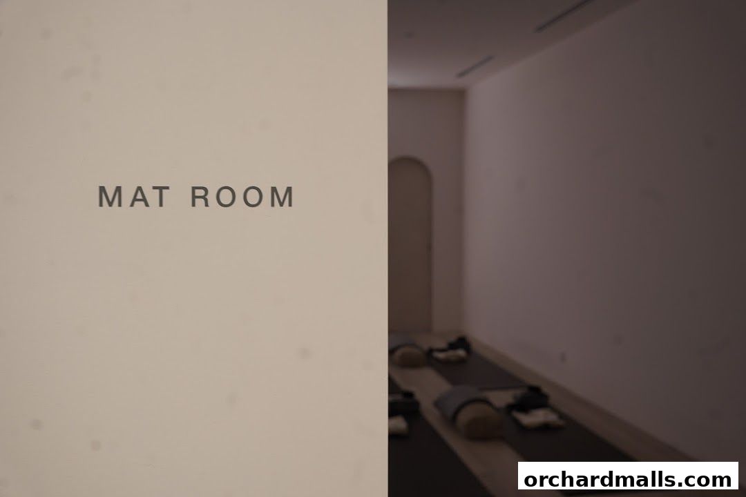 Interior view of a yoga studio's mat room with mats and props laid out.