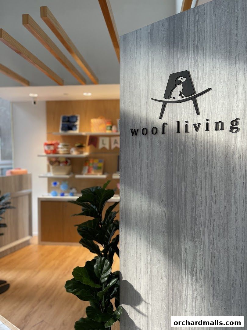 The entrance of Woof Living, a pet-friendly store, with its logo and interior visible.